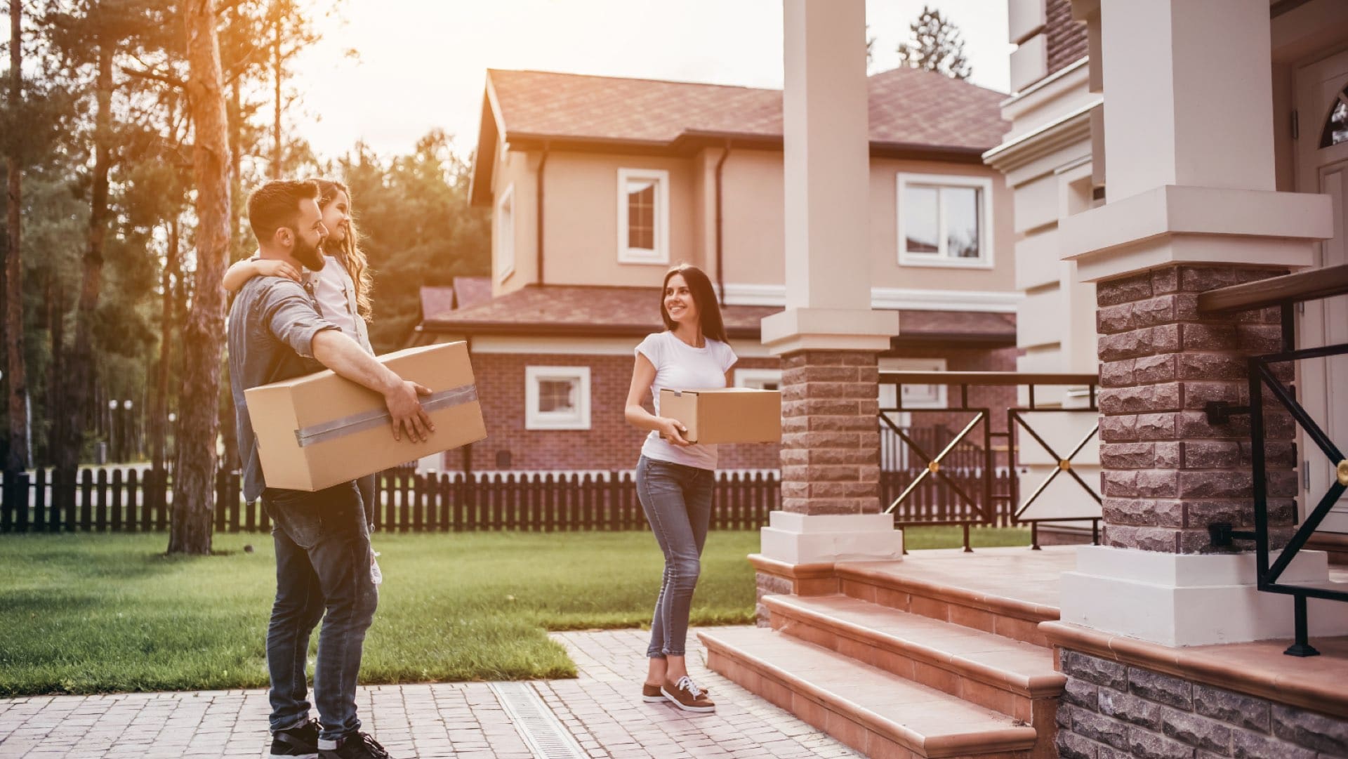 Family carrying moving boxes into their new home