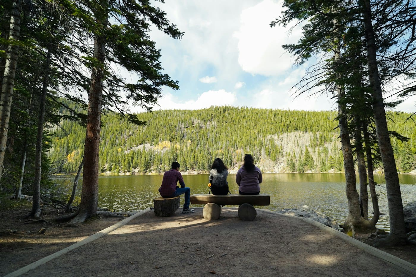 Three people on a bench by Bear Lake, Rocky Mountain National Park